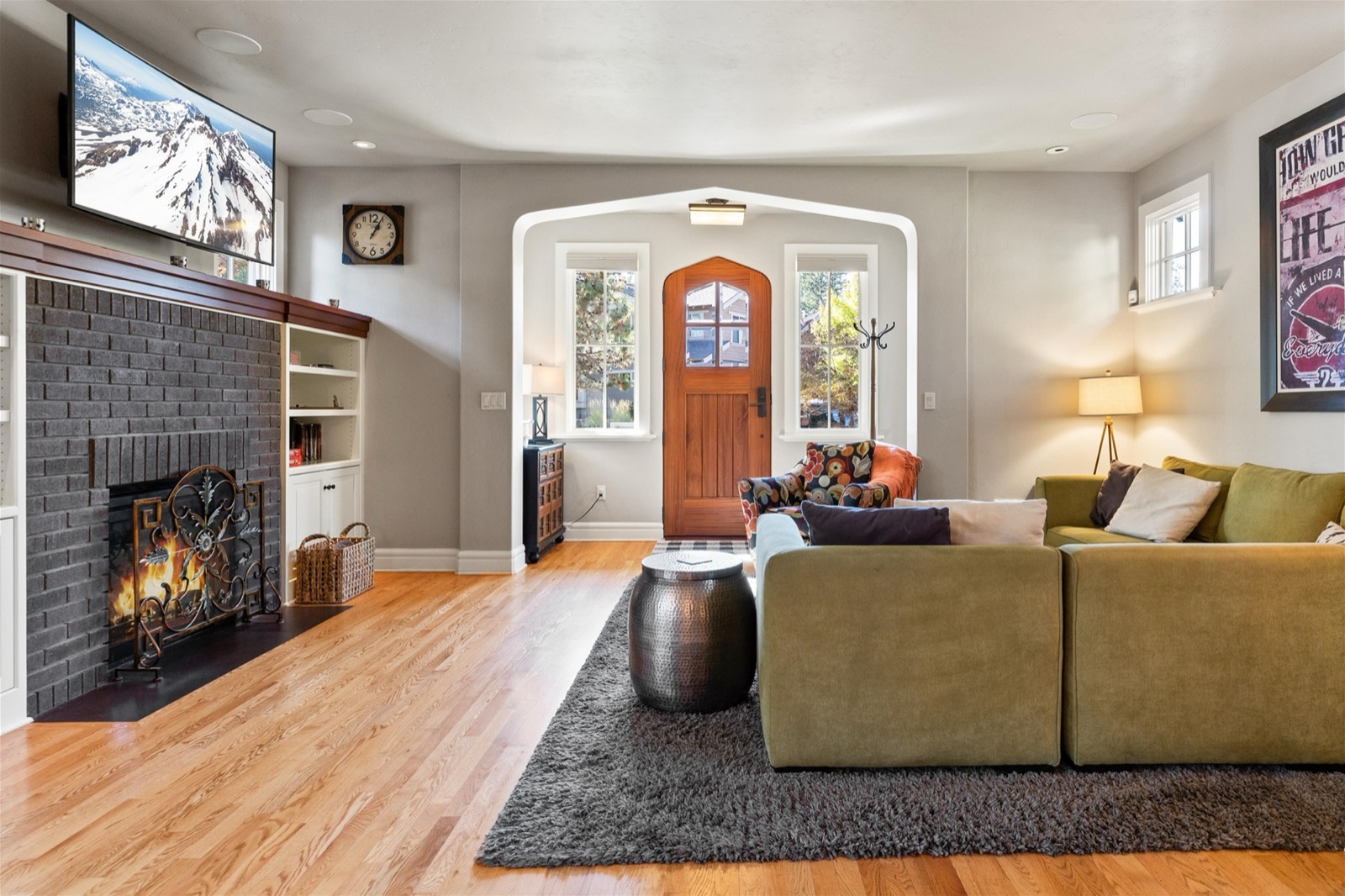 Living room with fireplace and arched entry at the Awbrey Rd vacation home in Bend
